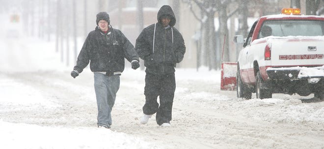 With snow heaped over the sidewalks Wednesday, these two take to the streets, walking down Federal Avenue Northwest in Massillon.