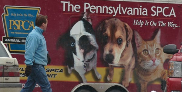 A man who said he works for the PSPCA but refused to give his name, walks by a PSPCA trailer at the Monroe shelter Friday morning.