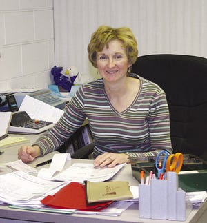 Cathy Fraher sits at her desk going over some paperwork at Fraher Ford. In recent years, gasoline prices and the economy have been a problem for car dealerships.