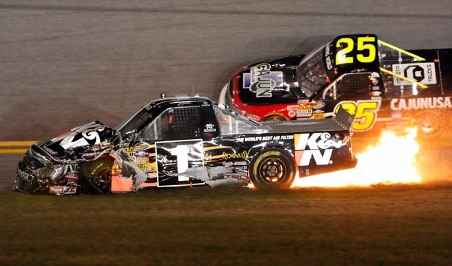 DAVE DODDS/Associated PressFlames erupt from Johnny Benson's truck as Terry Cook drives past during the NextEra Energy Resources 250 Truck series race Friday night at Daytona International Speedway.