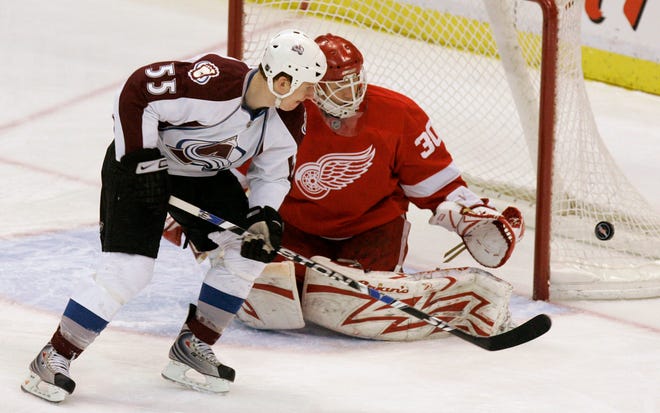 Detroit Red Wings goalie Chris Osgood (30) deflects shot by Colorado Avalanche forward Cody McLeod (55)during the first period of an NHL hockey game in Detroit, Sunday, Feb. 15, 2009. (AP Photo/Carlos Osorio)