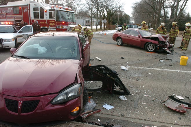 Holland Township firefighters clean up the scene of a two-car crash with injuries at the intersection of 136th Avenue and Felch Street Tuesday afternoon.