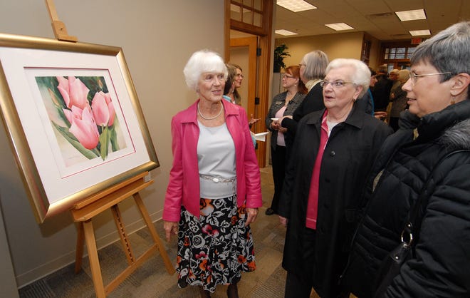 Local artist Maxine McLeod, left, chats with friends Elly Butler, center, and Lynn Bekins during a reception at the Tulip Time office Wednesday afternoon. McLeod painted the tulip image that was selected for the Tulip Time poster this year.