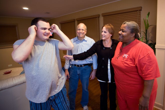 Eric Markin, an autistic 22-year-old, is pictured in his living room with father Larry, mother Beth and live-in house manager Rosemarie Clay in Skokie, Ill. PHOTO PROVIDED BY McClatchy Tribune Information Services