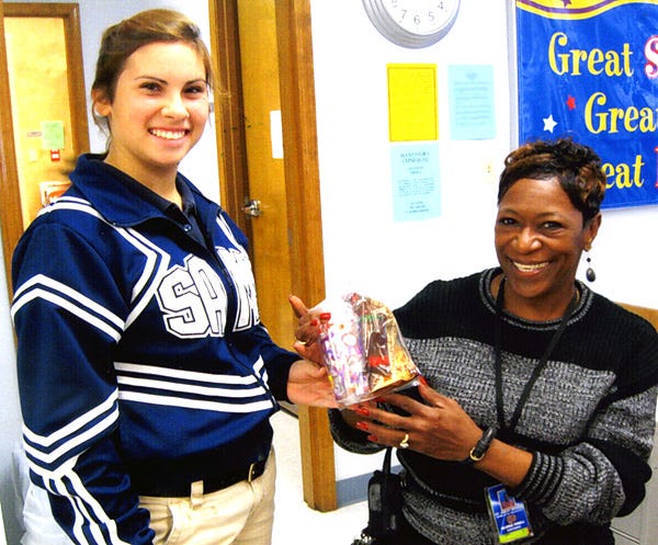 During “Support Staff Week” the St. Amant Beta Club wanted to show its appreciation for all that the staff does for the students and the school by making treat bags for the custodians, bus drivers and cafeteria workers. Top, students prepare goodie bags. Left, Abby LeBlanc, student, presents Gloria Pinell with a goodie bag.