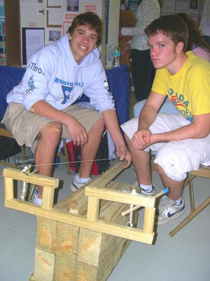 BETH REESE CRAVEY/My Clay SunRidgeview High students Jake Hartley (left) and Alec Epstein demonstrate their science project, called a ballista, at the Clay Rotary Science and Engineering Fair Tuesday. They came up with the crossbow project idea while playing a video game.