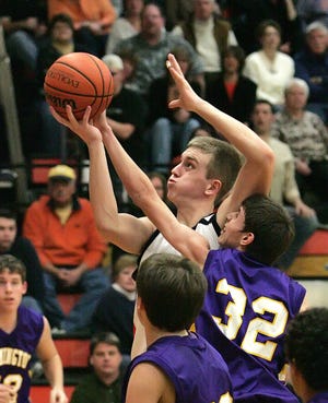 Macomb's James Souherland goes up for a shot while being guarded by Farmington's Scott Hammond during the Bombers' 41-27 victory over the Farmers. Southerland, one of five seniors honored during Macomb's senior night celebration, finished with seven points as the Bombers ended the regular season with a bang against Olympic Conference foes the Farmers.