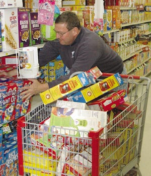 Art Bunting loads his cart with cereal on the way to winning the Amaizing Grocery Cart Race at County Market on Thursday. The event was sponsored by Livingston County Farm Bureau Women’s Committee and the food went to two area food pantries.
