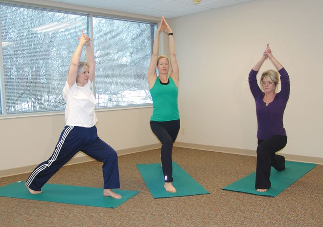 Women at the Center for Good Health, from left, Sharon Stradal, Tina VandeGuchte and Ginelle Koops, practice yoga.