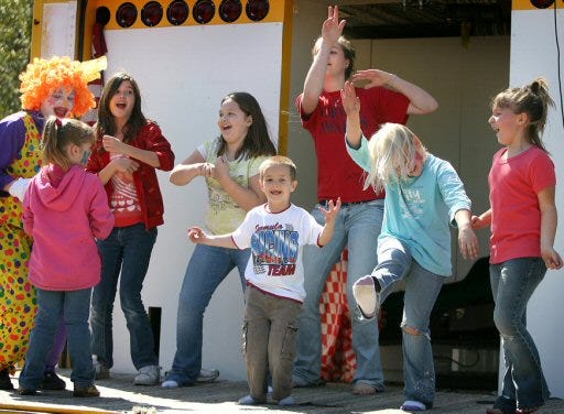 Children dance with clowns on stage during family day at the Mentoring Community Center in Ocklawaha on Saturday.
