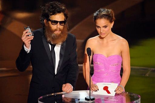 Comedian Ben Stiller, portraying Joaquin Phoenix, left, and actress Natalie Portman make the award presentation for achievement in cinematography during the 81st Academy Awards Sunday, Feb. 22, 2009, in the Hollywood section of Los Angeles.