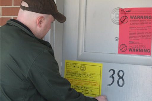 East Ridge investigator Josh Creel adjusts a quarantine notice on a motel room door at the Cascade Motel on U.S. Highway 41, Thursday, Feb. 19, 2009 in Chattanooga, Tenn. The meth makers used the room as a lab recently causing concern for future occupants.