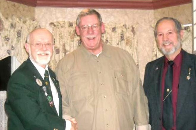 Visiting Governor Robert Argot, left, and Bussiere, right, installed new member William Sine. Argot gave a presentation on the theme of Lionism in today's world. The Stroudsburg Lions Club, chartered in 1925, received a banner patch.