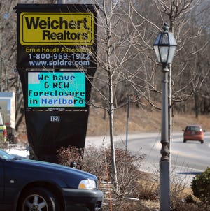 A Marlborough real estate company's electronic sign includes a message about new foreclosures.