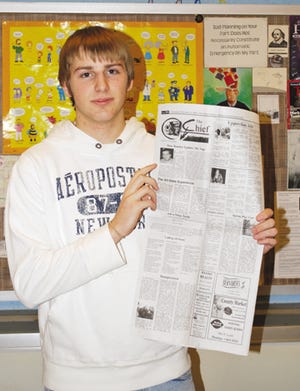 Junior Jake Long, student editor of The Chief, holds its latest issue. The student newspaper at Pontiac Township High School is celebrating its 90th anniversary under the current name.