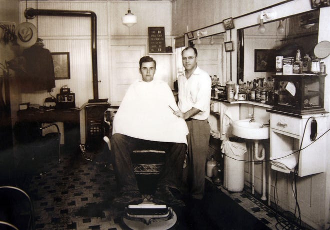This photo shows Rex Ford, who operated a barber shop in the building, with a customer. The mirrors are still there.