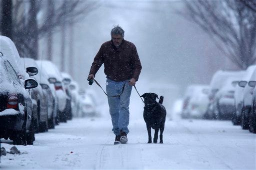 Sam Martineau and his dog Rawlie walk in a snow storm in Philadelphia, Monday, March 2, 2009.
