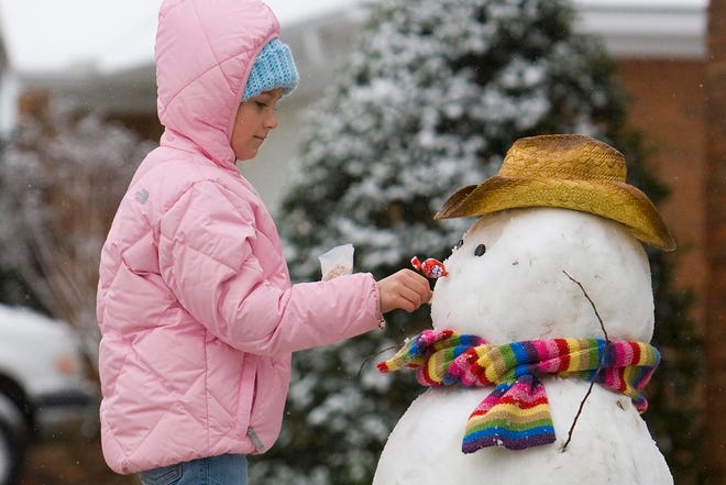 Taylor Smith, 9, puts the finishing touches on a snowman she built with help of her brother Hudson, 6, and her parents at their home in Tusca-loosa on Sunday. 

A blanket of snow covered Tuscaloosa Saturday night and continued into Sunday morning leaving residents without power and bridges iced over leading to several wrecks.