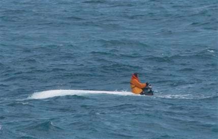 In this photo released by the U.S. Coast Guard, shows former University of South Florida football player Nick Schuyler clinging to the engine of an overturned boat in the Gulf of Mexico Monday March 2, 2009. Schuyler, Marquis Cooper, William Buckley and Corey Smith left Clearwater, Fla, on a fishing trip Saturday morning and did not return.