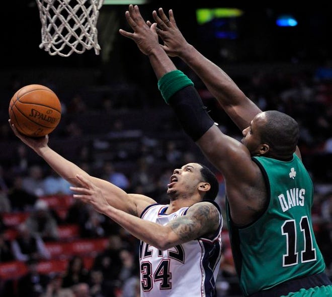 New Jersey's Devin Harris, left, goes up with the ball against Boston's Glen "Big Baby" Davis during the first quarter of Wednesday night's game.