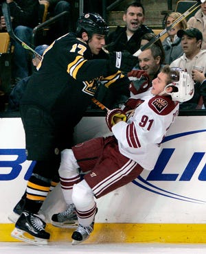 Milan Lucic of the Bruins checks Kyle Turris of the Phoenix Coyotes in the second period.