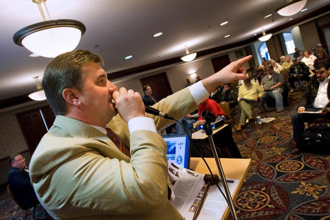 Auctioneer Rob Nord looks for bids Thursday as 12 properties go on the auction block during a foreclosure sale overseen by Rick Levin and Associates Auctions for Associated Bank at the Holiday Inn City Centre.