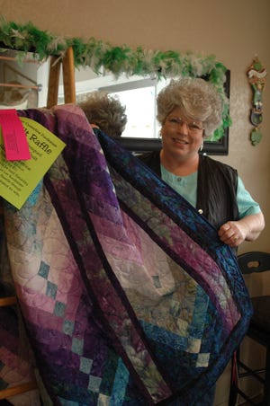 Helen Blackston of Hair Razors displays a custom-designed, queen-sized quilt she made and donated to the Diane Casterline fundraiser. Tickets are $2 each, or six for $10, and the drawing will be held Saturday, March 21 at the fundraiser dinner at the Gazelle Grange. Ticket-purchasers need not be present to win.
