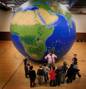 Students from the Clifford Marshall School in Quincy get a large scale lesson in geography from professors of Bridgewater State College using their "Earth Balloon" The twenty foot tall globe allows students to see the planet on grand scale, and get inside.