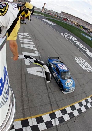 In a photo provided by Harold Hinson Photography, Kurt Busch takes the checkered flag to win the NASCAR Kobalt Tools 500 auto race at Atlanta Motor Speedway in Hampton, Ga., Sunday, March 8, 2009. (AP Photo/Harold Hinson Photography, Gregg Ellman) ** NO SALES **