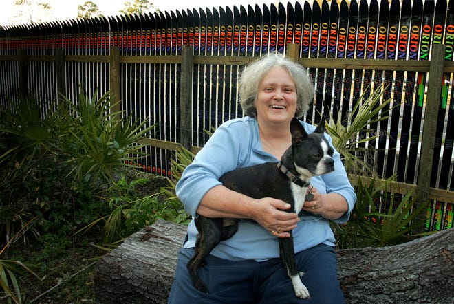 Carla "Jo" Elmore and her dog Jack are shown in front the unique snow ski fence she had built in her Palmetto Woods subdivision backyard.