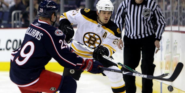 The Bruins' Andrew Ference clears the puck past the Blue Jackets' Jason Williams during the first period of Tuesday night's game.