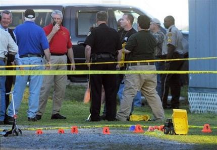 With a toy truck and a scooter seen in the foreground, law enforcement officials from across the state investigate one of the crime scenes of a shooting rampage in Samson, Ala. on Tuesday afternoon, March 10, 2009.