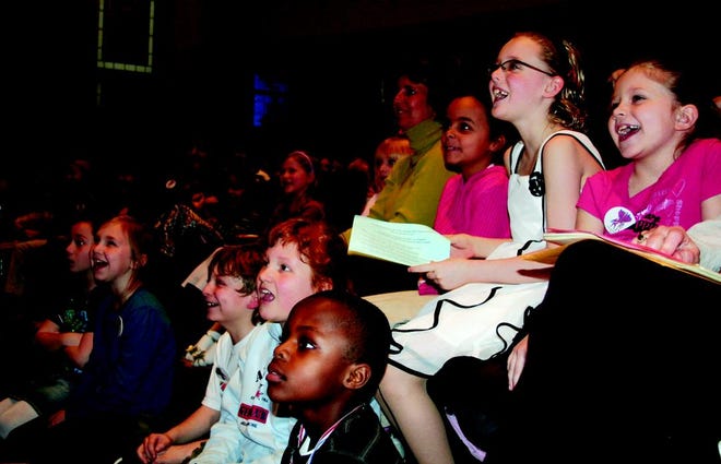 Children laugh as they watch their teachers perform student-written stories at the annual Young Authors event.