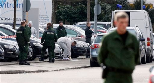 A police forensic expert works outside a car dealership, in Wendlingen, Germany, Wednesday March 11, 2009, where a 17-year-old gunman killed two bystanders before being shot and killed by police. The gunman, dressed in black, opened fire at his former high school in Winnenden, southwestern Germany, killing at least 15 people before police shot him to death, state officials said. Nine students and three teachers were among the dead, State Interior Minister Heribert Rech said. (AP Photo/Matthias Schrader)
