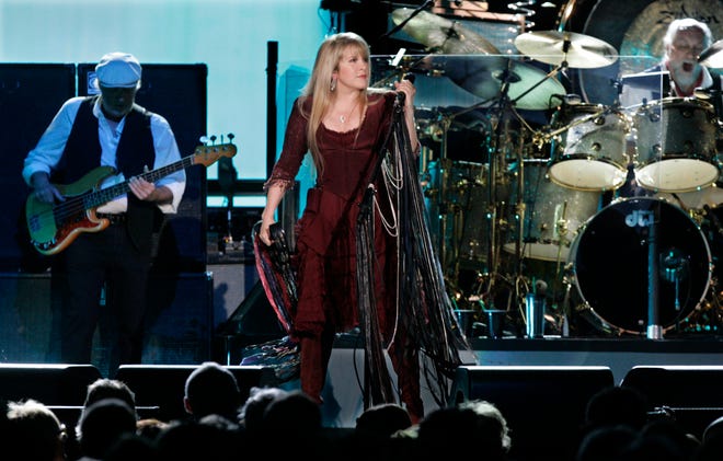 Fleetwood Mac vocalist Stevie Nicks, center, performs with band members John McVie , left, on bass and Mick Fleetwood on drums.