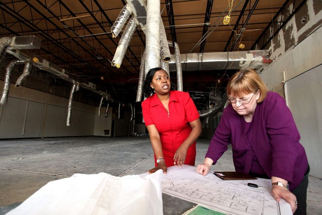 Carressa Hutchinson, Family Resource Center coordinator, left, and Elizabeth Curry, director of the Public Services Division for the Alachua County Library District, review plans for a new Neighborhood Resource Center on NE 16th Avenue on Tuesday.