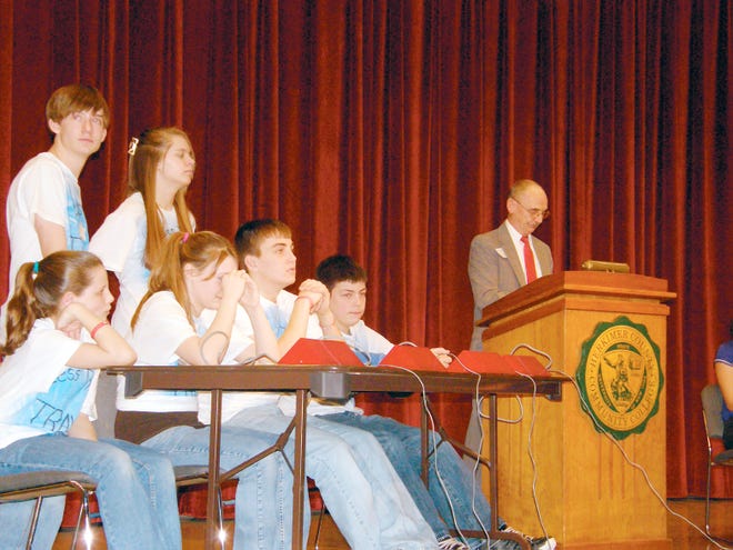 Members of the Mt. Markham drug quiz show team are shown thinking through an answer to a question. The team won the regional competition 18 to 9 over the Town of Webb team. Pictured from left: Seated Hannah Barrett, Katie Manion, Tyler Plows, and Travis Beach, captain. Standing alternates: Warren Salo and Miranda Bailey. The moderator Jack Kilty is shown at the podium.