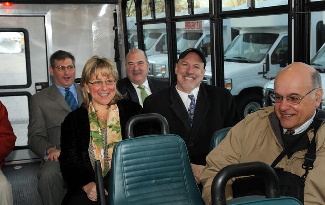 State Sen. Karen Spilka sits next to State Rep. Tom Sannicandro on the new MWRTA bus at 160 Waverley St. this morning. At rear left is state Rep. David Linsky.