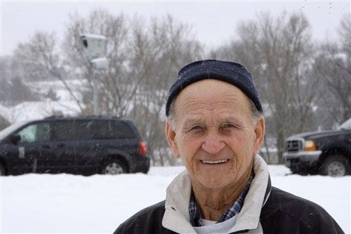 Richard Tarlton stands near a red light camera at the intersection where he got a traffic ticket, Tuesday, Jan. 27, 2009, in Clive, Iowa. As more cities sign up and others invest their profits into more cameras, the companies that operate the cameras expect increased revenue for years to come.