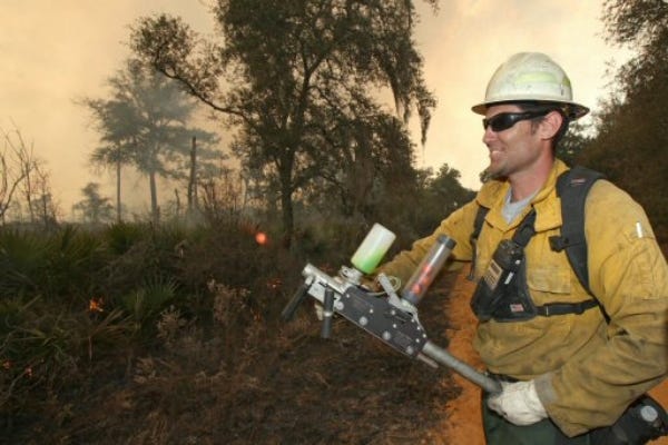 Paul Varnedoe an engine captain with the U.S. Forest Service our of Osceola National Forest uses an launcher to start a back fire in the Juniper Prairie Wilderness area in the Ocala National Forest on Friday.