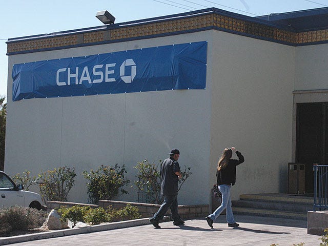 Temporary signs from JPMorgan Chase covered the outside lettering at the Washington Mutual Barstow branch on East Main St. as customers visited the bank Monday. WaMu will completely change into Chase by September, according to a branch official.