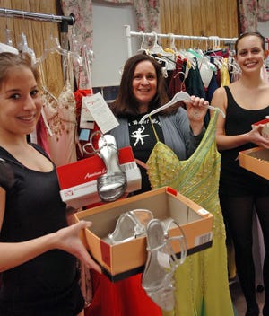 Mellisa Kelley Clark, owner of Melissa Kelley's Dance Studio of Braintree and her students have donated gowns and shoes to the Belle of the Ball cause, which provides prom attire to students in need. From left, Jessica Fay, 18, of Braintree; Melissa Kelley Clark, owner of the Dance Studio; and Sarah Graham, 17, of Braintree, display some of the gowns and shoes they have collected.