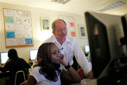 Peter Vos, 54, who once ran an Internet start-up, now teaches 8th-grader Chido Makoni computer programming at Argyle Middle School in Silver Spring, Md., Tuesday, Feb. 24, 2009. Plenty of people dream of leaving their jobs to become teachers; these days more people are actually doing it. (AP Photo/Lawrence Jackson)
