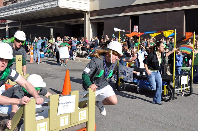 A team from HTK Architects, left, takes on one from Housing and Credit Counseling during the Great Topeka Bed Race in downtown Topeka. View more photos at Spotted!