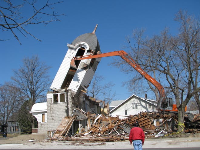 Former members gathered to watch the razing of the Sixth Reformed Church/Crossroads Chapel, Monday March 16. Hope College owned the church built at the corner of Lincoln Avenue and 12th Street in 1918. Crossroads Chapel was using it temporarily. Crossroads has moved into Midtown Center at the corner of River Avenue and 16th Street.
