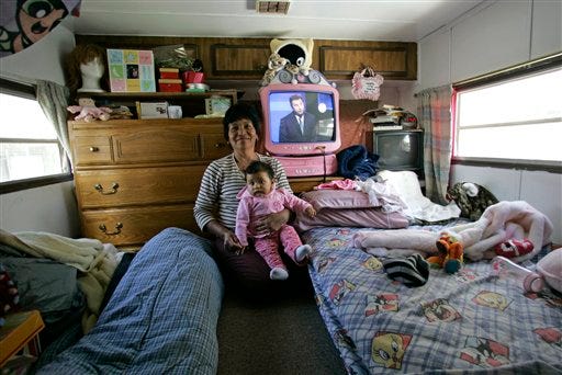 Lupe Ramos holds her 8-month-old granddaughter, Jennifer Hernandez, in her trailer in the San Ysidro section of San Diego, Calif. where she splits her television viewing between San Diego and Tijuana stations Tuesday, Feb. 17, 2009. (AP Photo/Lenny Ignelzi)