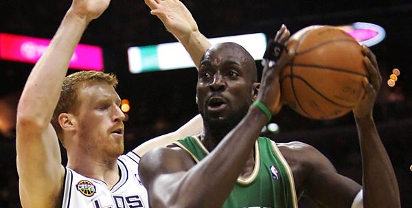 The Celtics' Kevin Garnett drives to the hoop against the Spurs' Matt Bonner during the first quarter of Friday night's game. Garnett played sparingly in his first game in a month for Boston, which won a nail-biter.