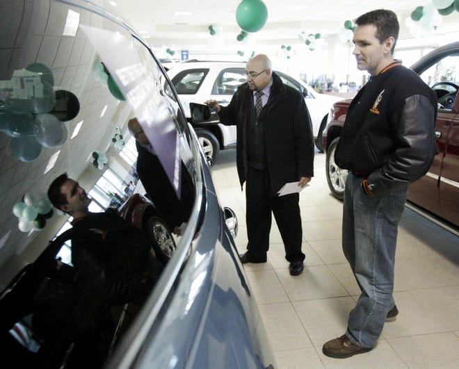 Jerry Mulvihill, second from left, of Alsip, Ill., talks with car salesman Gerardo Rangel at the Apple Chevrolet dealership in Orland Park, Ill., Saturday, Feb. 28, 2009. While new vehicle sales have fallen to 27-year lows, used cars are in greater demand, so their values are rising. Meanwhile, automakers and dealers desperate to sell new models have been piling on rebates and incentives that have sent prices plummeting. (AP Photo/Charles Rex Arbogast)
