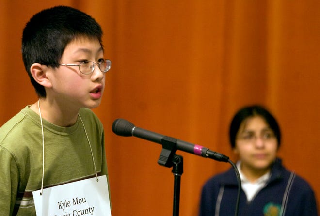 Kyle Mou spelled his way to his third victory in as many years after 22 rounds of spelling in the Grand Final Spelling Bee at WEEK television studios in East Peoria. Runner-up Maya Jain (background) went out on the word "heliolatry."