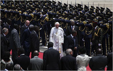 The pope walking alongside President José Eduardo dos Santos, after reviewing an honor guard at the Luanda airport.